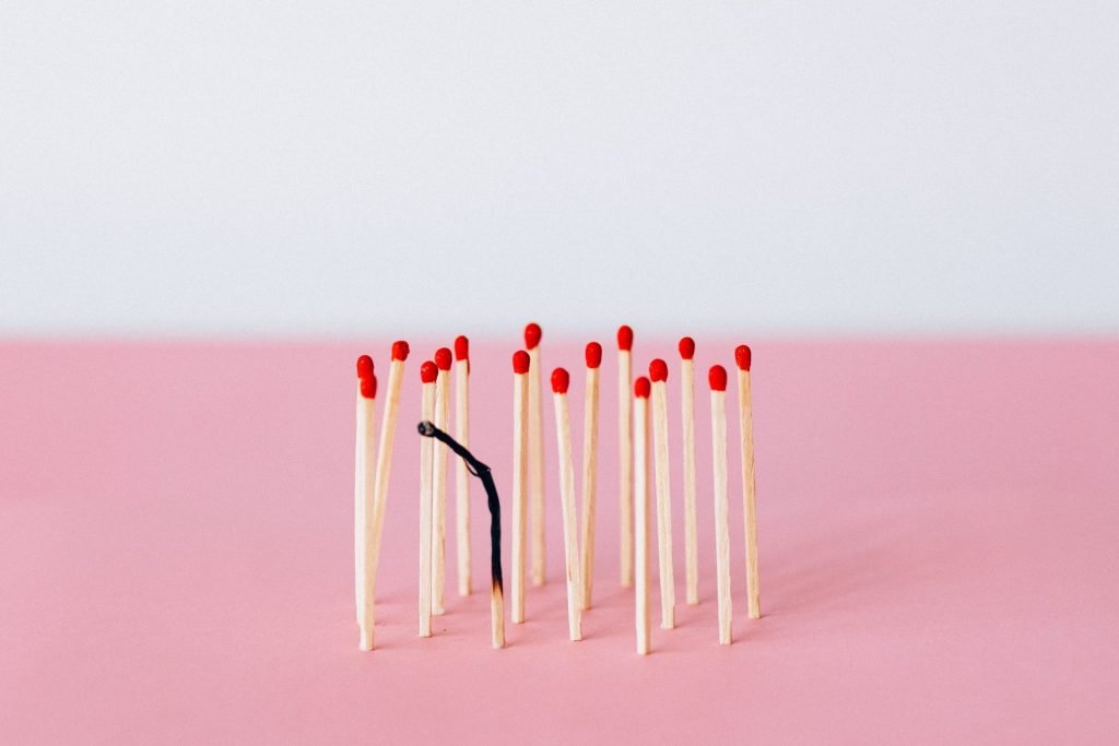 Imagem de palitos de fósforos novos e um deles queimado até a base, representando o burnout, que é o esgotamento emocional