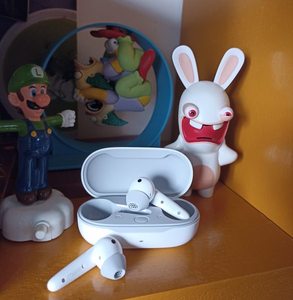 Review Huawei FreeBuds SE - a imagem mostra o estojo de carregamento e um dos fones fora do estojo; ao fundo há três bonecos: do luihi, do game Super Mario Bros., um coelho Rabbid e, mais ao fundo, Krusty o palhaço, de Os Simpsons