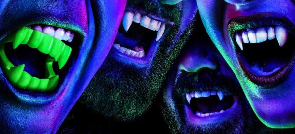 Em um tom azulado, imagem mostra 4 bocas com dentes de vampiros, representando os personagens da série What We Do in the Shadows, que entra na temporada 5 em julho de 2023