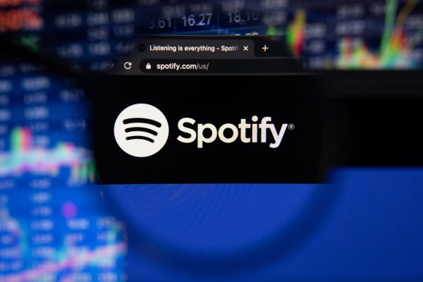 Imagem mostra a tela com o logotipo do Spotify em um smartphone, vista por uma lupa