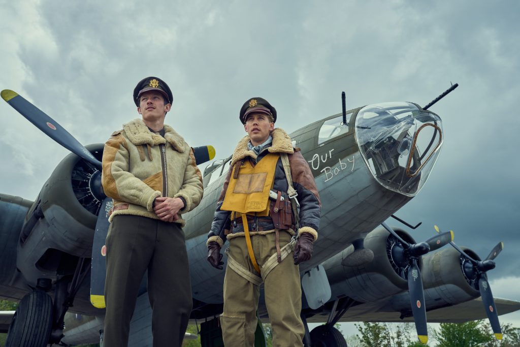 Imagem de divulgação da minissérie Masters of the Air com Callum Turner e Austin Butler vestidos em uniforme militar e ao lado de um avião. A série é uma das estreias da Apple TV+ para janeiro de 2024